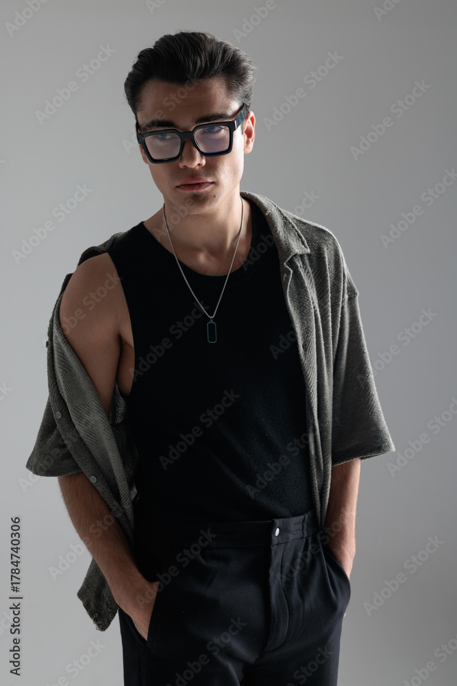 Fototapeta premium sexy casual man with glasses holding hands in pockets and looking away