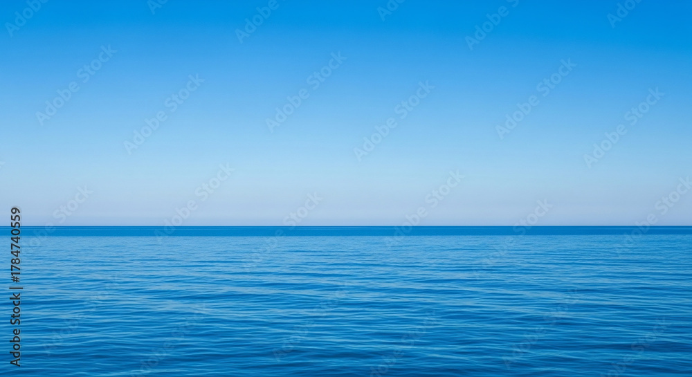Fototapeta premium Vibrant blue ocean meets the clear sky on a sunny day at the horizon