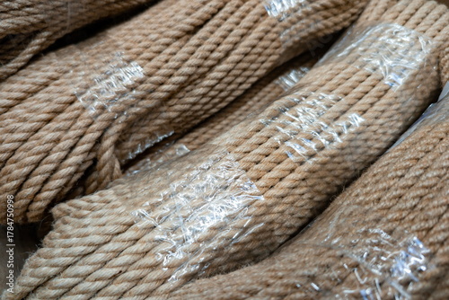 Bundles of natural fiber rope stored neatly in clear plastic wrapping at a local hardware store for various outdoor and indoor projects