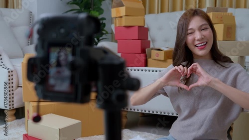 A young Asian content creator using a camera live streaming online and chat with customer. Business online influencer on social media concept, Online Selling, Online Shopping market. Selling at home.