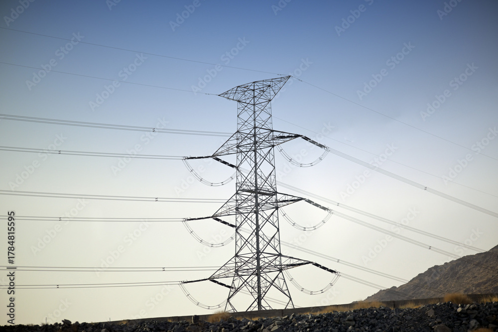 Fototapeta premium Power transmission tower providing energy across a mountainous landscape
