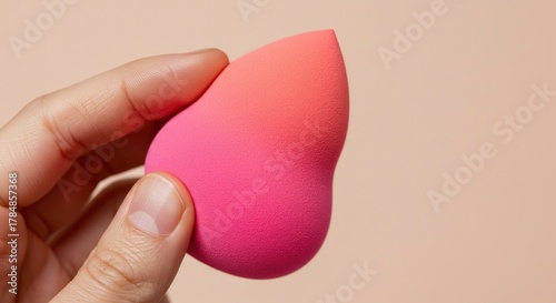 Hand Holding Pink and Orange Makeup Sponge