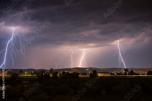 Multiple lightning during thunderstorm at night, over hills near croatian city of Slavonski Brod