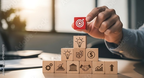 Reach goals with strategic business planning shown with wooden blocks stacked like a pyramid, representing success, vision and team work in a modern office