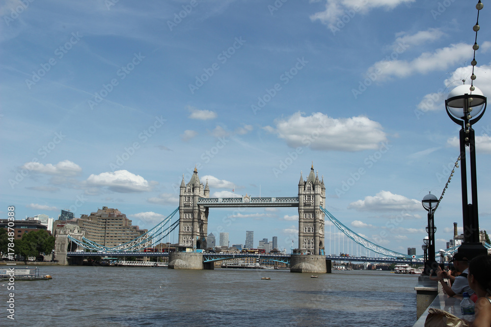 Obraz premium View of Tower Bridge in London under a clear blue sky with fluffy clouds on a sunny day