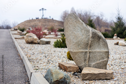 An Orthodox cross on a mountain and a decorative stone with a cross in a religious park. 