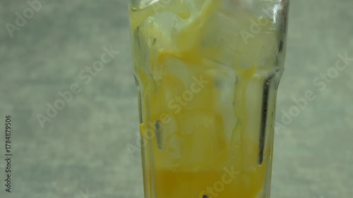 Refreshing orange juice pouring into glass with ice, creating a refreshing summer beverage 
