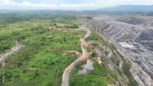The image shows an aerial view of a rural landscape featuring a network of winding canals or small rivers crossing through green and brown terrain. open channel at reclamation of mining project