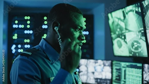 Vigilant Security Officer Monitors Advanced Surveillance Systems in High-Tech Data Center Control Room