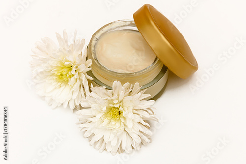 White glass container on white background with white flowers.