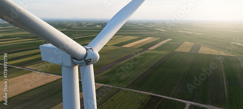 Aerial view of wind turbine on an agricultural filed at sunset. Close up of blades