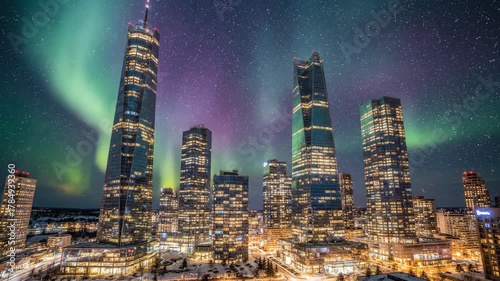 A cityscape at night showcases illuminated skyscrapers under a sky illuminated by the aurora borealis and stars