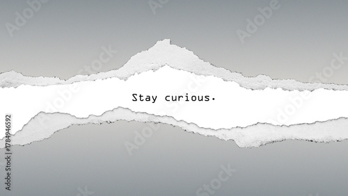 Motivational quote “Stay curious” on torn paper background. Minimal modern design encouraging creativity, curiosity, and lifelong learning.