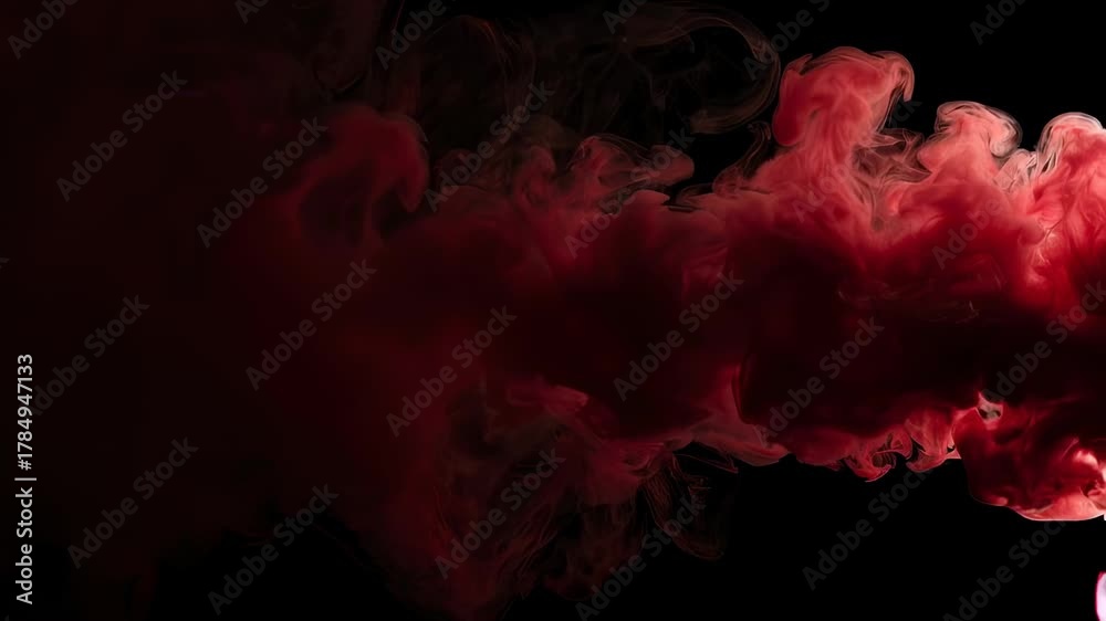 A vivid red cloud-like shape swirls against a stark black background, creating a mesmerizing effect