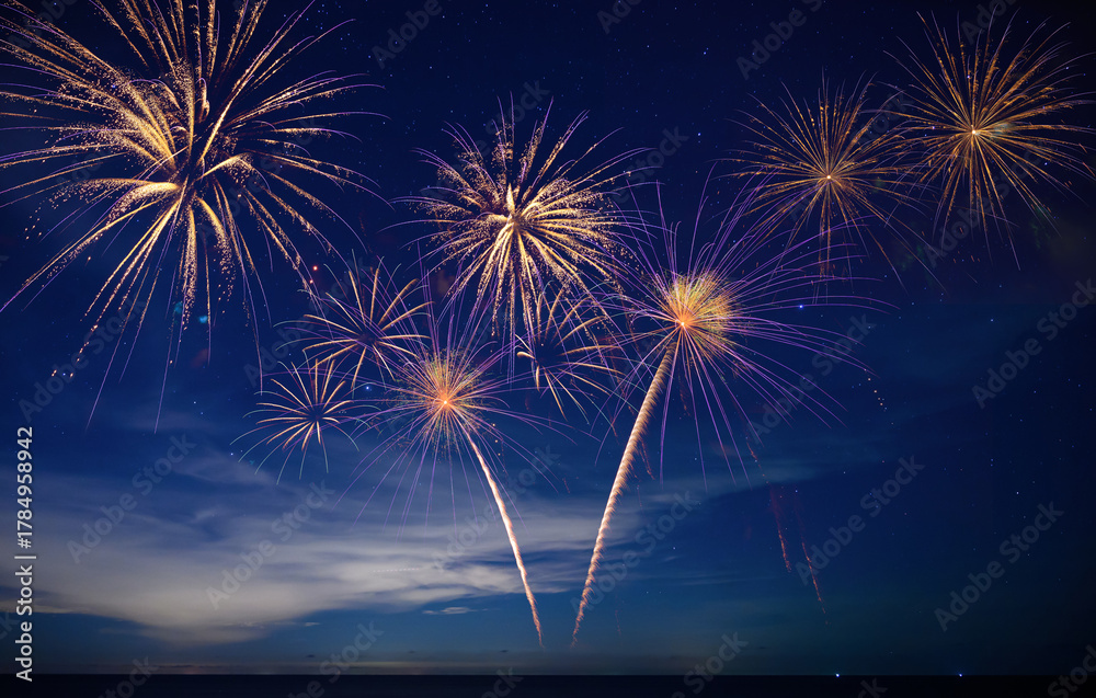 Fototapeta premium Stunning fireworks illuminate the night sky over the ocean, symbolizing celebration, hope, and the excitement of welcoming 2026 with bright new beginnings.