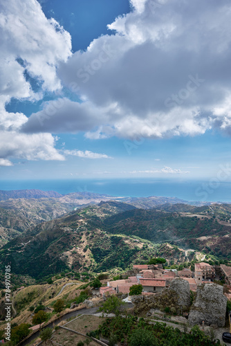 Panoramic view of the Aspromonte mountains and the Ionian Sea coast near Bova, Calabria, southern Italy with small hilltop village and scenic Mediterranean landscape under dramatic clouds