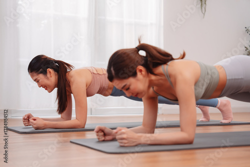 Wallpaper Mural Asian women doing plank pose together on yoga mats at home, building core strength and fitness motivation in indoor workout session, promoting healthy lifestyle and bodyweight training. Torontodigital.ca