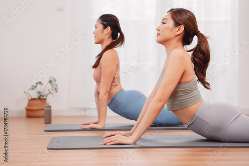 Wallpaper Mural Stretching exercise with Asian women doing mobility flow on yoga mats at home, showing flexibility training, core strength, and wellness lifestyle for healthy living. Torontodigital.ca