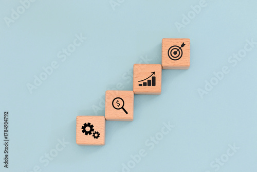 Four wooden cubes  showing business icons Concept of business process, analysis, finance, and goal achievement