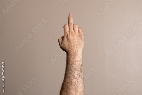 A hand with a finger pointing up in a gesture of disapproval