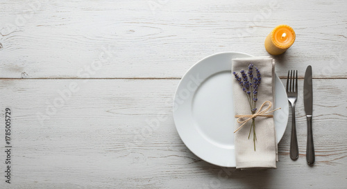 Elegant lavender table setting perfect for weddings, anniversaries or special dinners. Features a plate, napkin, silverware, candle, and beautiful floral accents. Ideal for celebration.  