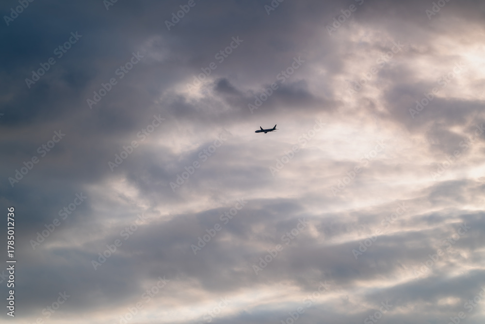 Fototapeta premium A dramatic video of a passenger airplane flying left under high altitude clouds Filmed in Shimen New Taipei City Taiwan on a beautiful summer afternoon.