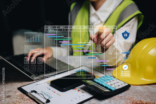 Project management concept. Engineer analyzing digital Gantt chart with data visualization for construction planning, scheduling, and performance monitoring using technology tools.