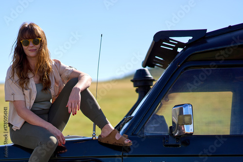 Ginger woman with sunglasses on a land cruiser Safari