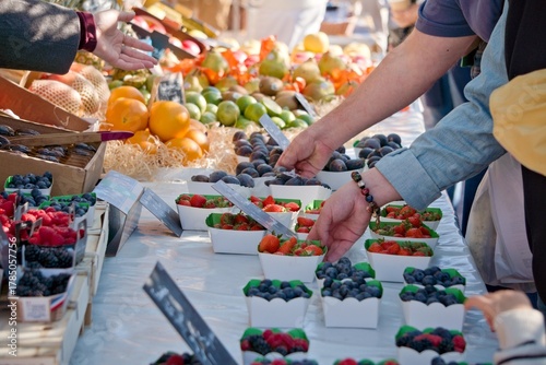 Clients en train de choisir des fruits et légumes frais sur un marché ensoleillé de Nice, côte d'azur