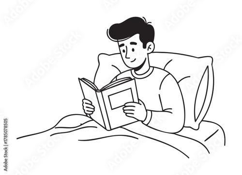Young male reading a book while lying in bed with a pillow behind him, wearing a comfortable sweater.