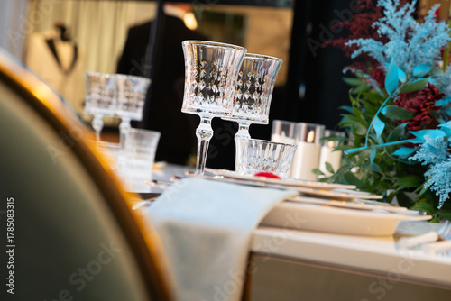 Photography Elegant wedding table setting with crystal glasses, fine china plates, and delicate floral arrangement