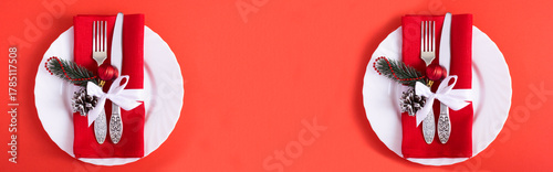 Christmas setting the table with red napkin on the white plate on a red background. Top view. Copy space.