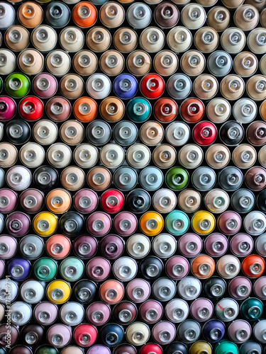 A background of colorful spray cans. Spray cans of graffiti paint.