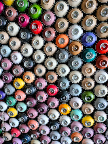 A background of colorful spray cans. Spray cans of graffiti paint.