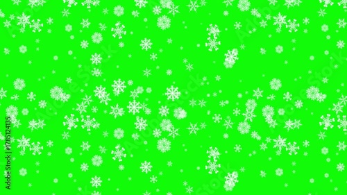 Festive winter background featuring delicate white snowflakes falling against a vibrant green backdrop creating a cheerful holiday atmosphere