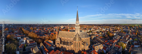 A stunning aerial view of De Gouwekerk in Gouda, with its majestic spire rising above the historic canals and rooftops of the old Dutch city.