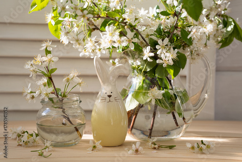 Easter still life with blossoming branches, decorative Easter bunny on the table