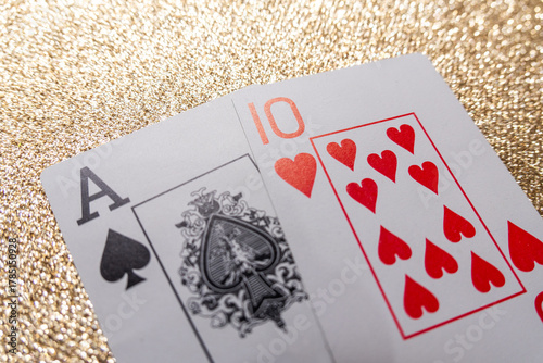 Photograph of a set of cards making a winning hand, Natural Blackjack, on a gold background