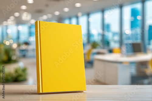 Bright yellow book mockup offers blank cover for creative publishing design in a modern workspace setting with plenty of natural light