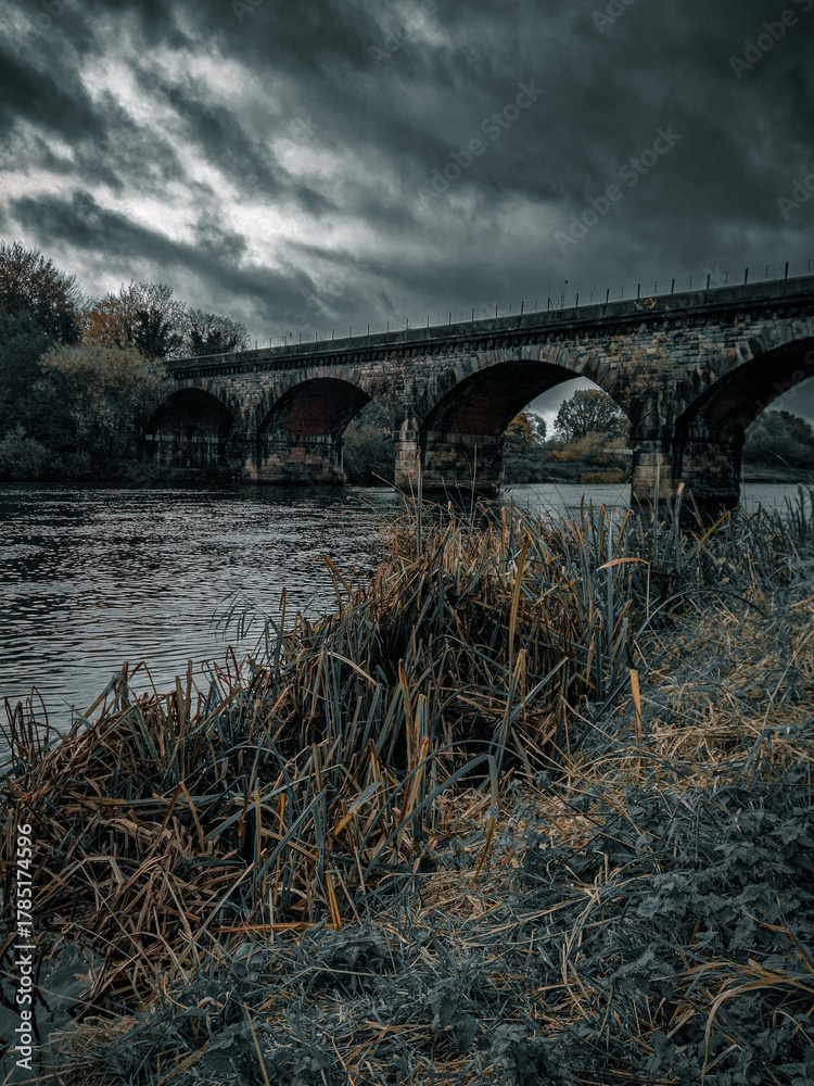Fotografie Dramatic Autumn Sky Over Historic Stone Railway Viaduct Crossing the River Trent