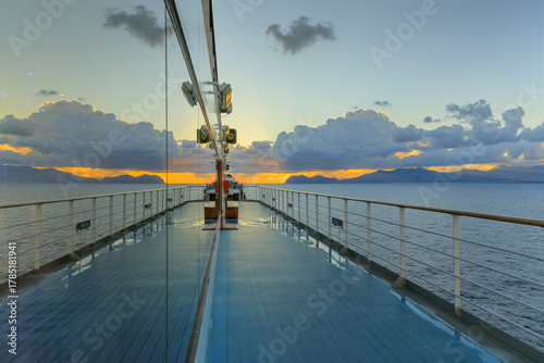 Sea horizon at sunrise from deck of cruise ship with Sicilian coast near Palermo, southern Italy.