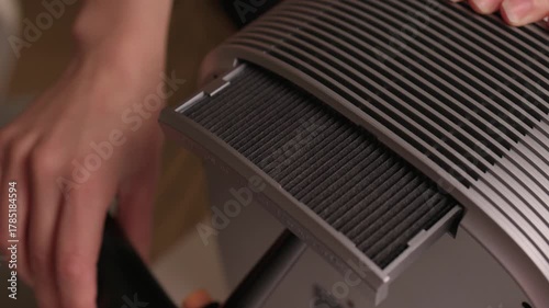 Cleaning filter with air blower, Removing dust from air purifier filter carefully, Thorough cleaning of air purifier filter using air blower to enhance air quality