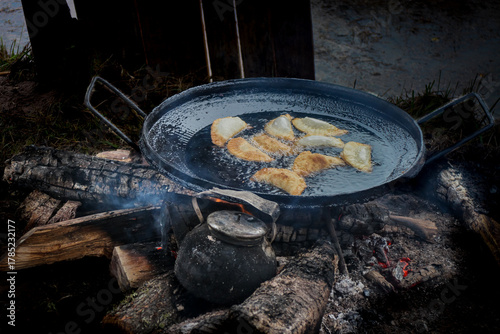 Traditional fried empanadas over a rustic campfire