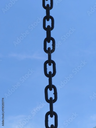 Vertical Metal Chain Links Against Clear Blue Sky