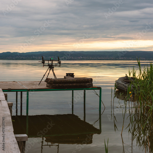 Fishing rods and inflatable boat on calm lake