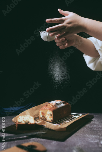 パウンドケーキにパウダーシュガーを振りかけるパティシエ
