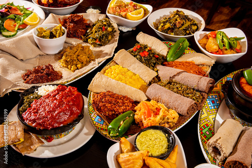 A variety of Ethiopian meat and vegetable dishes with rolls of injera flat bread on a party buffet