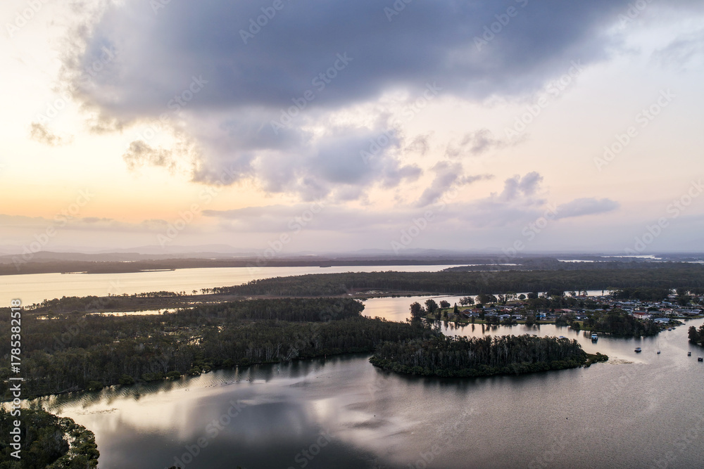Obraz premium A breathtaking aerial view of Forster on the Mid North Coast of New South Wales, showcasing turquoise ocean waters, white sandy beaches, and the bridge linking Forster and Tuncurry. The scenic coastli