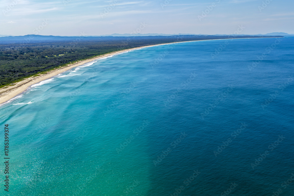 Fototapeta premium A breathtaking aerial view of Forster on the Mid North Coast of New South Wales, showcasing turquoise ocean waters, white sandy beaches, and the bridge linking Forster and Tuncurry. The scenic coastli