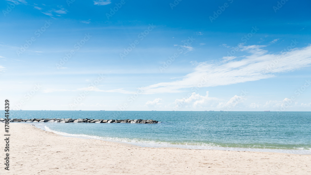 Obraz premium Clean beach area and clear blue sky and turquoise sea with coastal rock barrier. Time to travel with a bright atmosphere at Rayong Thailand.